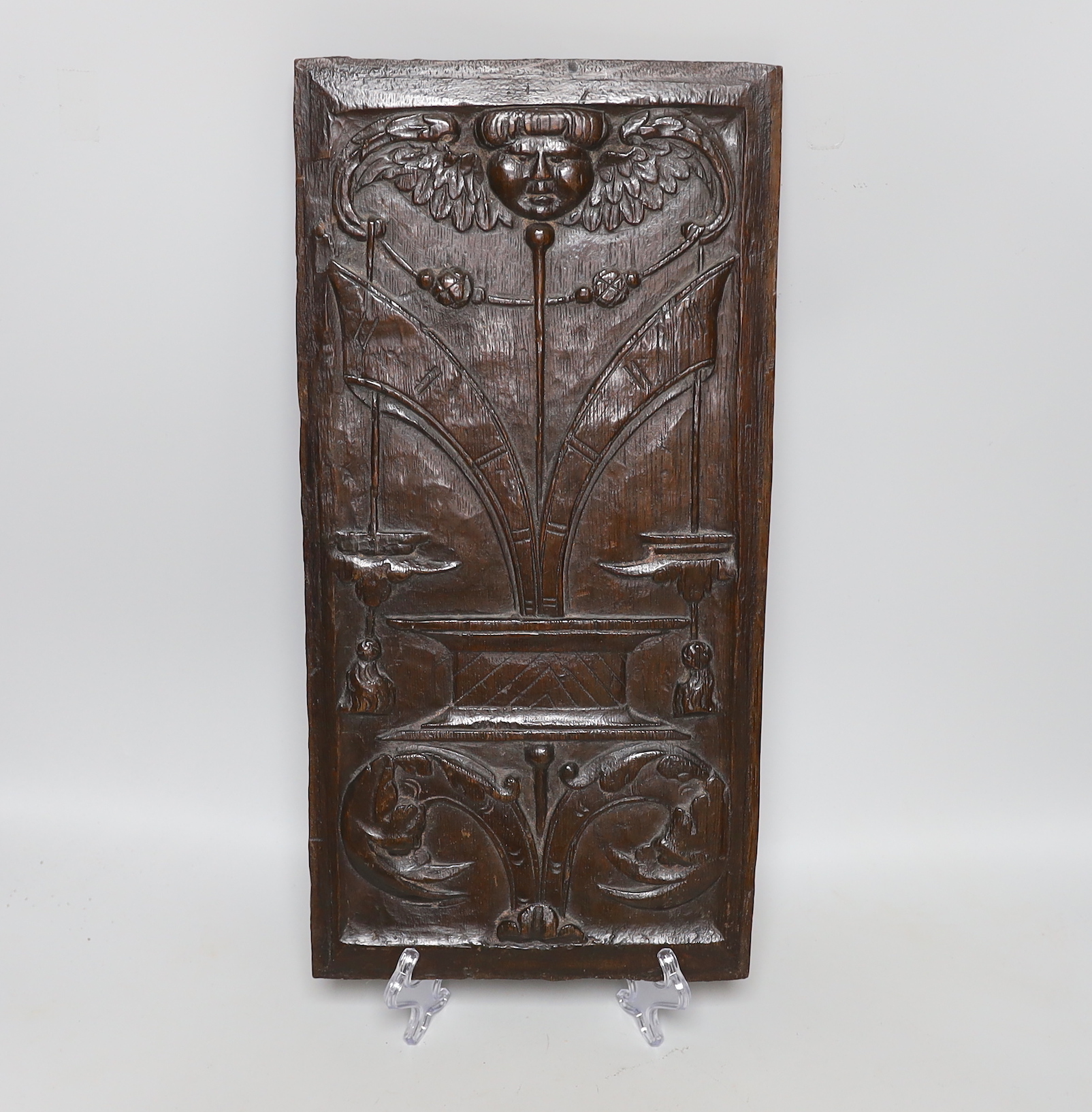 A 17th century carved oak panel, 47x23cm